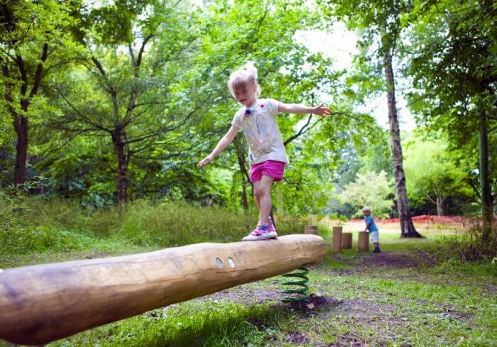 Young girl playing on one of the balance beams